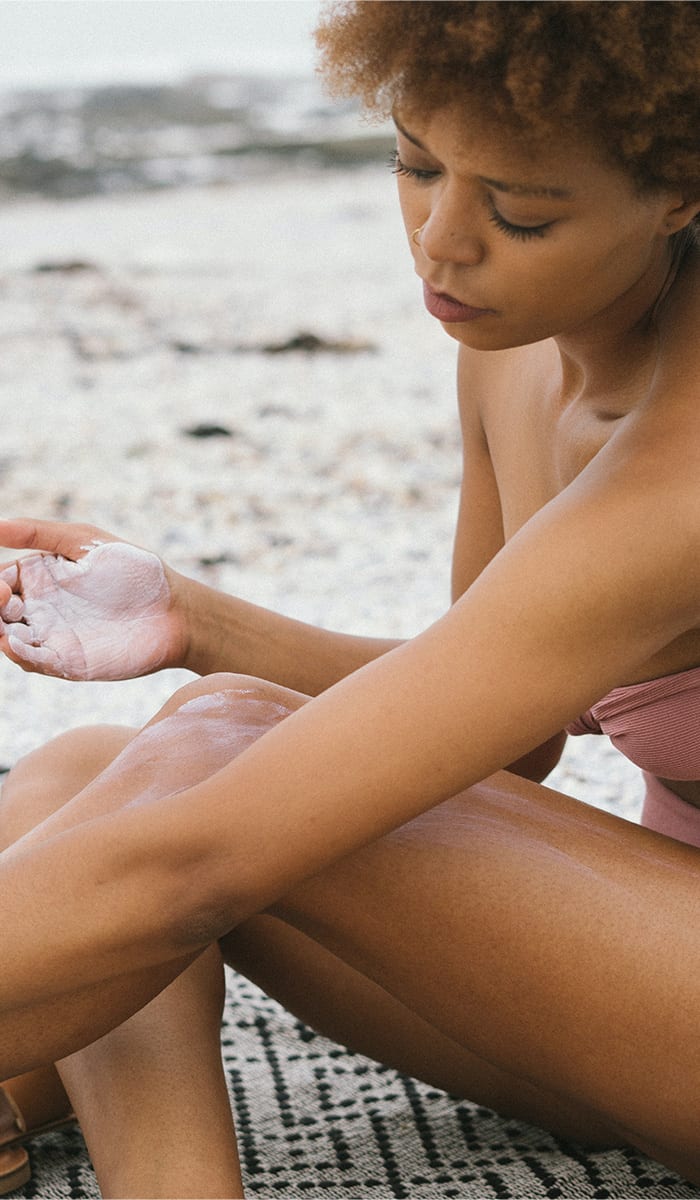 woman putting on sunscreen